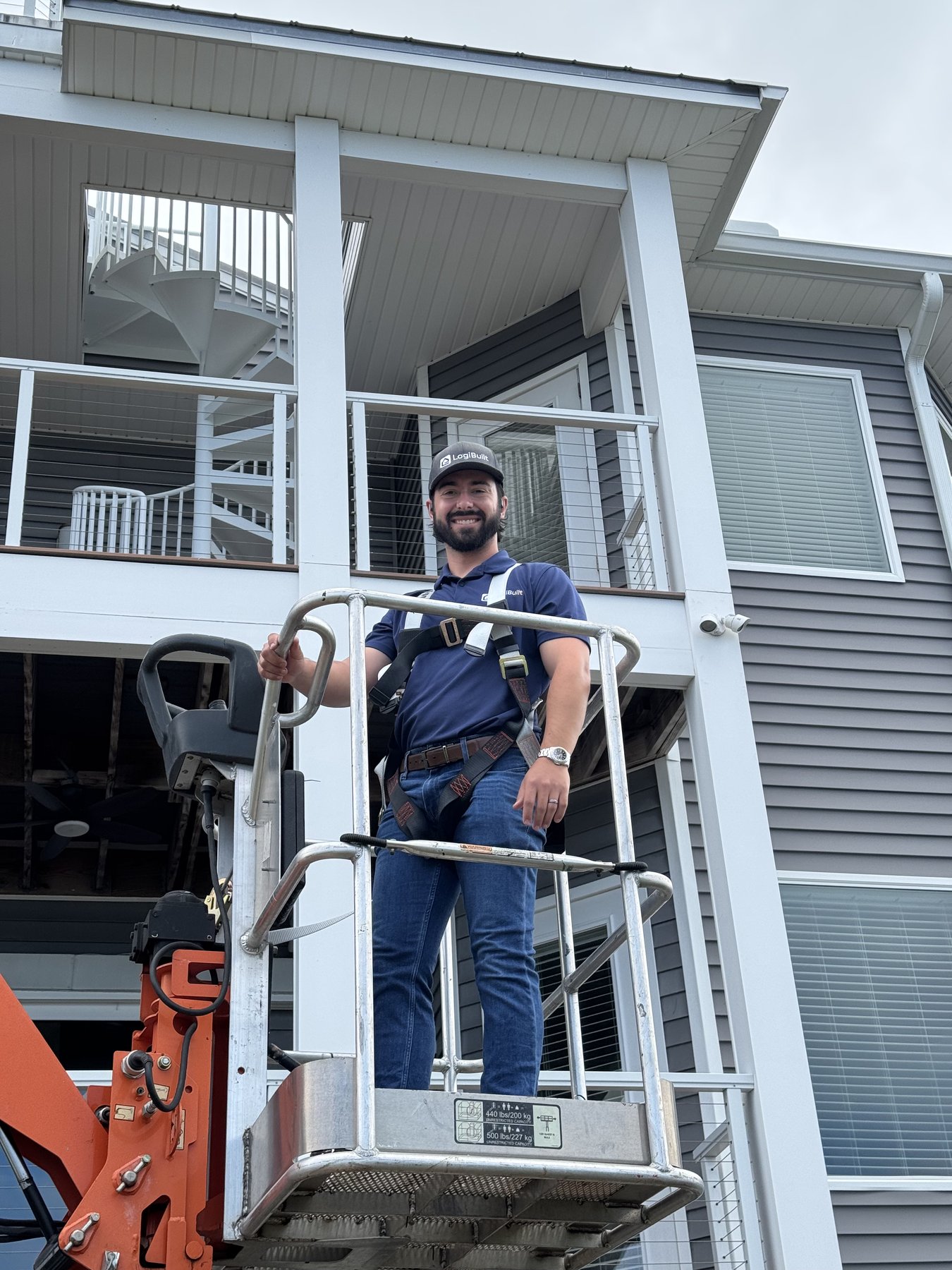 LogiBuilt owner Tyler Peterson on a boom lift during an exterior install