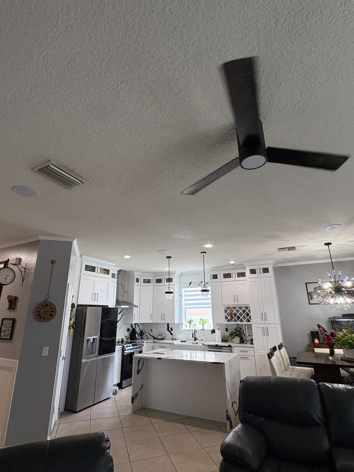 Flush-mounted in-ceiling speakers installed in an open kitchen and living area