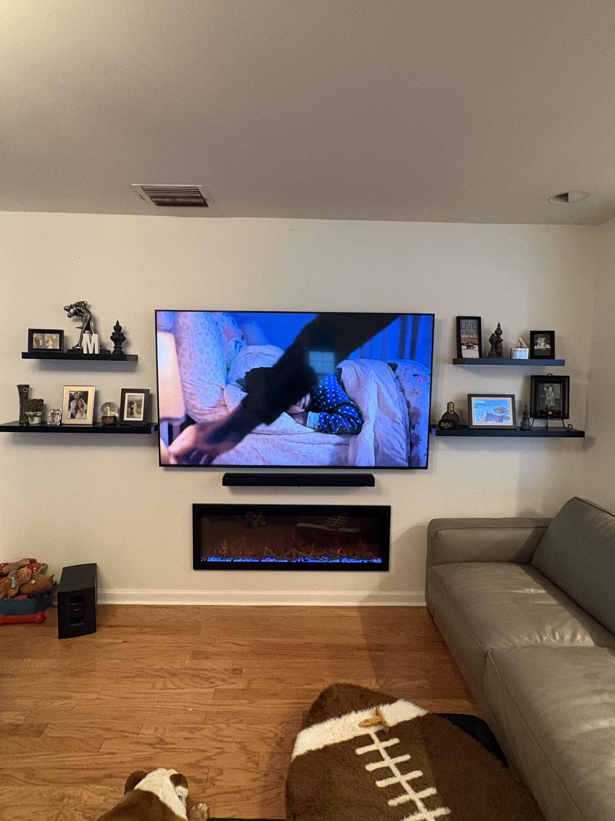 Wall-mounted TV over electric fireplace with soundbar in Tampa home