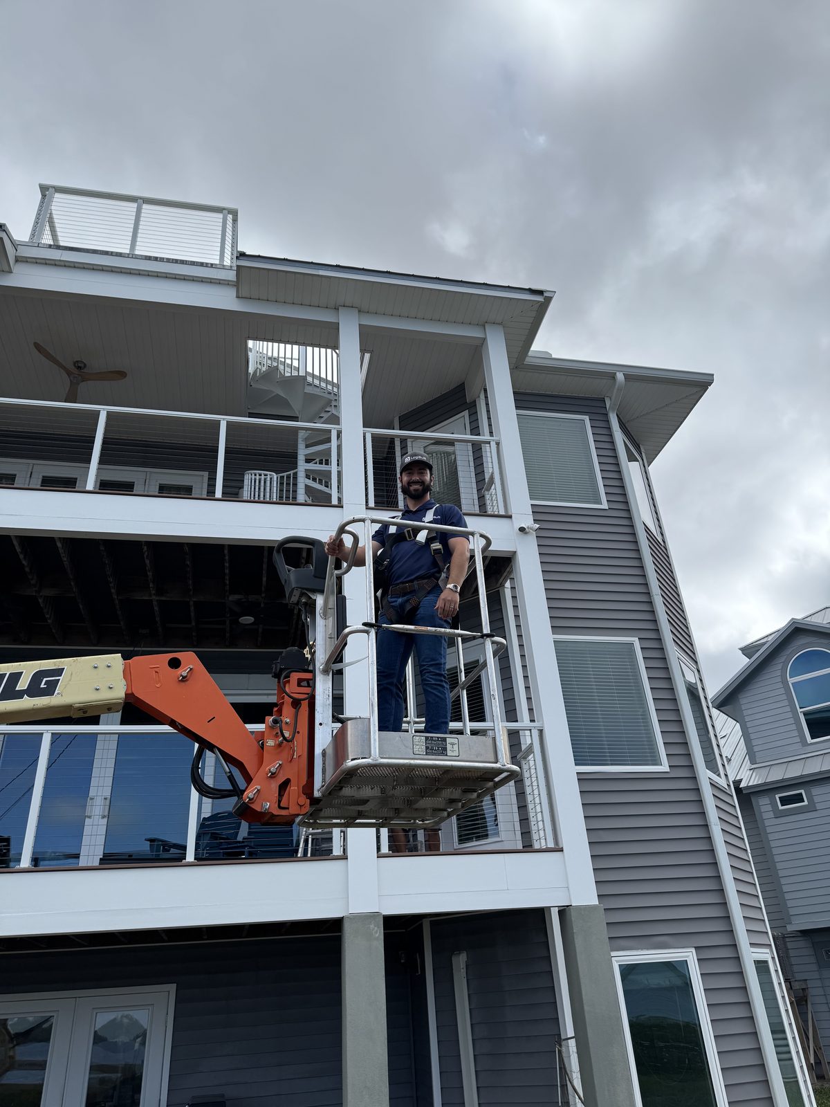 LogiBuilt installer on a boom lift installing exterior home technology